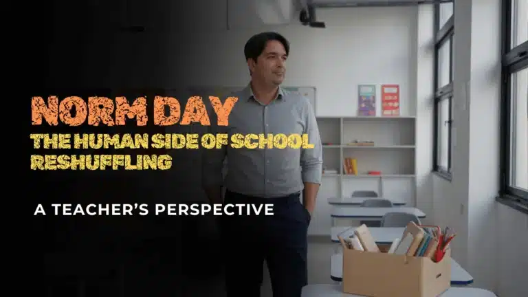Teacher standing in a classroom beside a box of supplies, reflecting on Norm Day and the impact of school reshuffling on students and staff