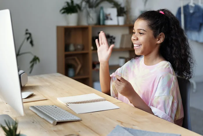 Student raising her hand during online class.